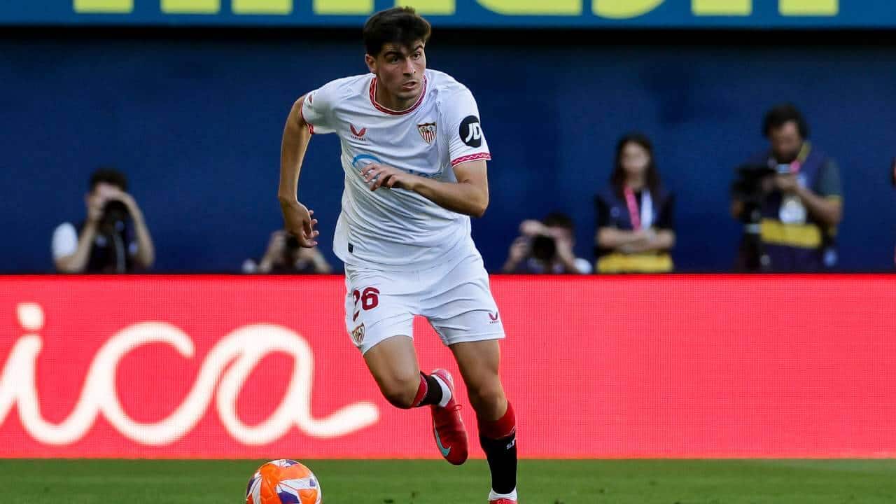Chi è Juanlu Sanchez Il terzino spagnolo Juanlu Sánchez corre con la palla al piede indossando la maglia del Siviglia